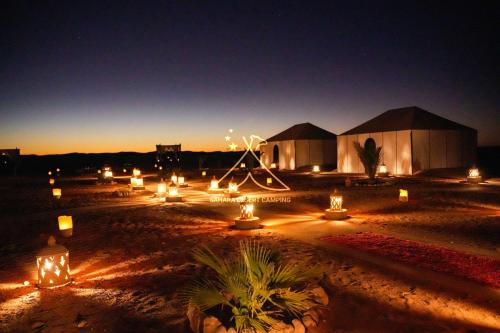 grupa domków letniskowych w nocy z oświetleniem w obiekcie Sahara Desert Camping Merzouga & Erg Chebbi Dunes w mieście Arfud