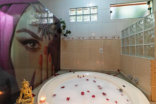 a bathroom with a large tub with red hearts on it at Pousada das Nascentes - Brotas in Brotas