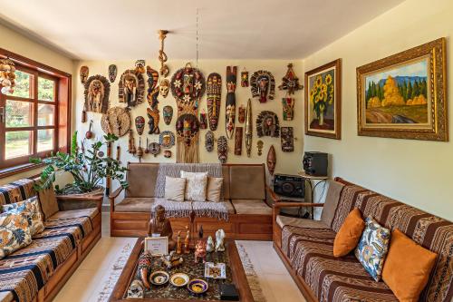 una sala de estar llena de muebles y una pared cubierta de arte. en Pousada das Nascentes - Brotas, en Brotas