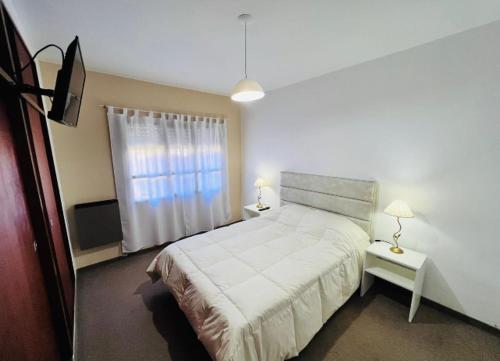 Un dormitorio con una cama grande y una ventana en Madryn home Pto Madryn en Puerto Madryn