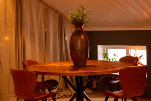 a vase sitting on top of a wooden table at Mysig lägenhet med öppen planlösning på hästgård. in Ljung