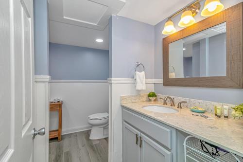a bathroom with a sink and a toilet and a mirror at 125 Atlantic Avenue Unit D - Pet Friendly! Walk To the Beach and Pier! 1BR -1BA - Sleeps 2-4 guests! in Myrtle Beach