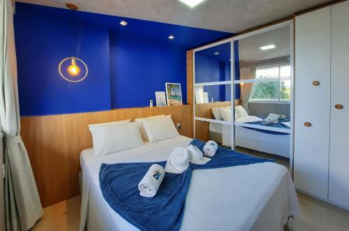 a bedroom with two beds and a blue wall at One Milenio - Luxuoso e Moderno Studio no Cocó in Fortaleza