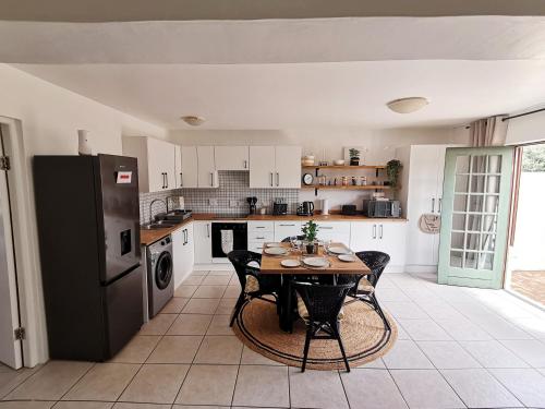 a kitchen with a table and a black refrigerator at Beachfront apartment in a secure complex in Port Alfred