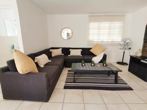 a living room with a black couch and a table at Beachfront apartment in a secure complex in Port Alfred