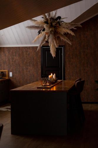 a room with a table with candles and a chandelier at Mysig lägenhet med öppen planlösning på hästgård. in Ljung
