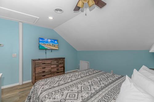 a bedroom with blue walls and a bed and a tv at 125 Atlantic Avenue Unit H - Pet Friendly! Walk To The Beach and Pier!1BR -1BA - Sleeps 4 guests! in Myrtle Beach
