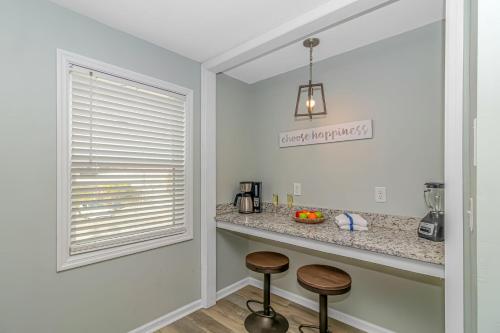 a kitchen with two stools in front of a counter at 125 Atlantic Avenue Unit G1 - Pet Friendly! Walk To The Beach and Pier! 2BR -1BA - Sleeps 6 guests! in Myrtle Beach