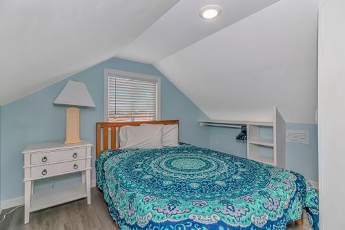 a blue bedroom with a bed and a table and a lamp at 125 Atlantic Avenue Unit G2 -Pet Friendly! Loft Apartment -Sleeps 2-4 guests! in Myrtle Beach