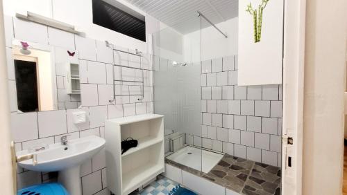 Baño blanco con lavabo y espejo en Villa Majorelia, en Vieux-Habitants