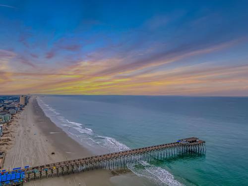 a view of a beach with a pier in the water at 125 Atlantic Avenue Unit G2 -Pet Friendly! Loft Apartment -Sleeps 2-4 guests! in Myrtle Beach