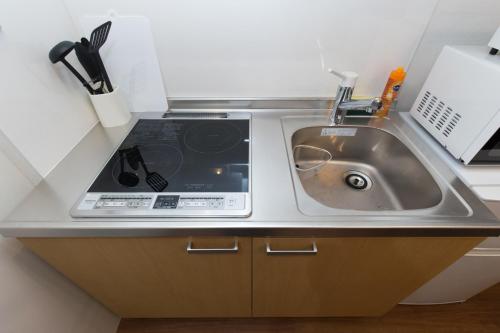 a kitchen with a sink and a microwave at Amber Iidabashi - Vacation STAY 87112v in Tokyo