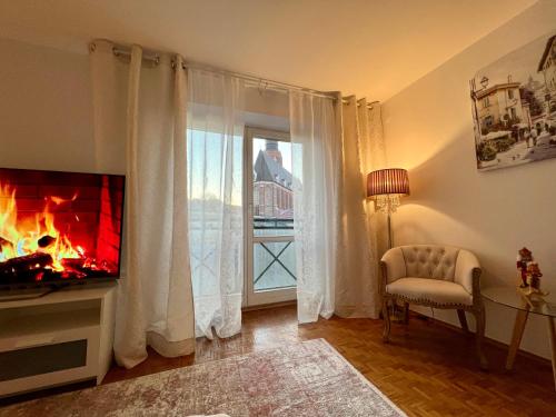 sala de estar con chimenea, TV y ventana en Louis & Elza Old Town Romantic apartments, en Wroclaw