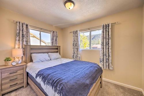 a bedroom with a bed and two windows at Hike, Bike and Fish Gem with Hot Tub in Woodland Park in Woodland Park