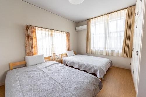 a bedroom with two beds and two windows at Yuan - Vacation STAY 01317v in Matsue