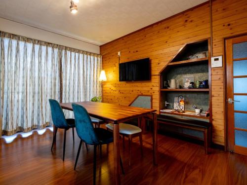 une salle à manger avec une table en bois et des chaises bleues dans l'établissement Yuan - Vacation STAY 01317v, à Matsue