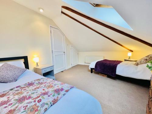a bedroom with two beds in a attic at Dapps Hill Haven - between Bristol and Bath, both 9 mins by train! in Keynsham