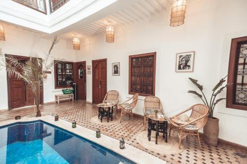 a house with a swimming pool and chairs and a table at Riad Dar Beldia and Spa in Marrakesh