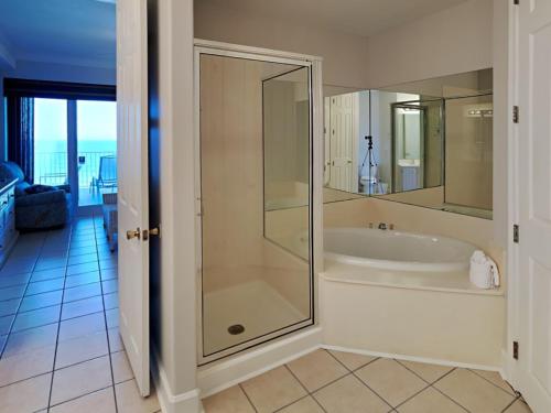 a bathroom with a tub and a glass shower at Regency Isle #609 in Orange Beach