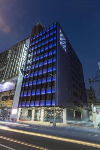 a tall building with blue windows on a city street at The Cloud Hotel in Taichung