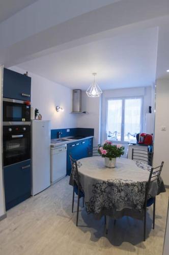 une cuisine avec une table avec un vase de fleurs dessus dans l'établissement Cocooning chez Corinne , Gérardmer, à Gérardmer