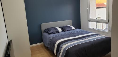1 dormitorio con paredes azules y 1 cama con 2 almohadas en La Plume d'Or - Wifi - Parking Privé en Lens