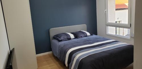 a bedroom with blue walls and a bed with two pillows at La Plume d'Or - Wifi - Parking Privé in Lens