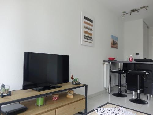 un salon avec une télévision à écran plat sur une table dans l'établissement Appartement moderne 2 pièces avec balcon et WIFI, proche centre Sarzeau et plages - FR-1-639-48, à Sarzeau
