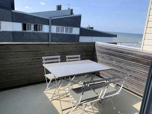 une table et deux chaises assises sur un balcon dans l'établissement Appartement proche plage avec parking et balcon - FR-1-482-102, à Fort-Mahon-Plage