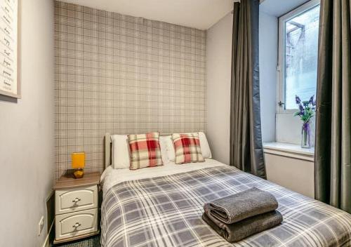 a bedroom with a bed with two pillows and a window at Townhouse Apartments 4 Bedroom High St Montrose in Montrose