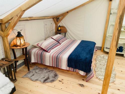 a bedroom with a bed in a tent at Umpqua's Last Resort - Wilderness Cabins, RV Park & Glamping in Idleyld Park