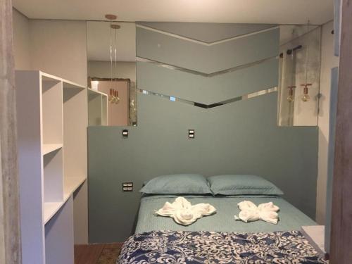 a bedroom with a bed with two towels on it at Aconchego das flores in Campos do Jordão