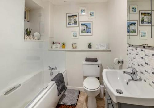 a bathroom with a tub and a toilet and a sink at Townhouse Apartments 4 Bedroom High St Montrose in Montrose