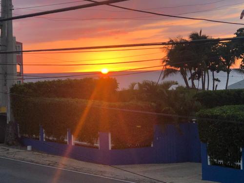 a sunset over a street with the sun setting in the distance at Las Olas Beach apartments in Arecibo