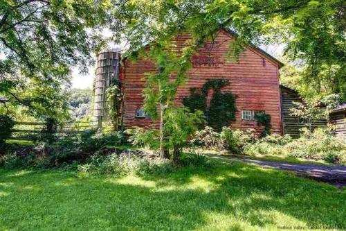 an old red brick barn in a field of grass at Wonderful Farm Escape With Swim Creek & Hiking Trails in Saugerties