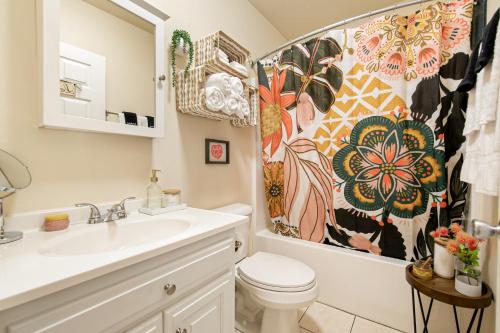 a bathroom with a sink and a toilet and a shower curtain at The Little Rock House in Bentonville