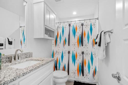 a bathroom with a toilet and a shower curtain at The Sinatra in Bentonville