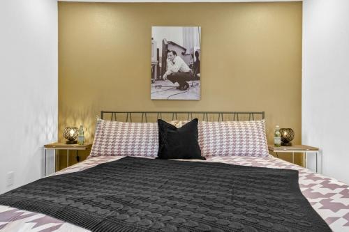 a bedroom with a bed with a black comforter at The Sinatra in Bentonville