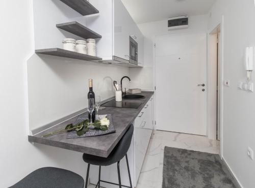a kitchen with white walls and a counter with a sink at Studio apartman Rose in Vinkovci