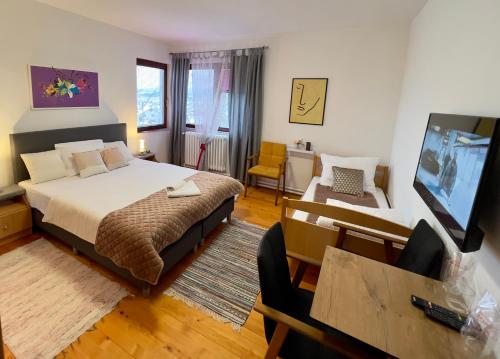 um quarto com uma cama e uma televisão em Apartman GM - sobe em Pale