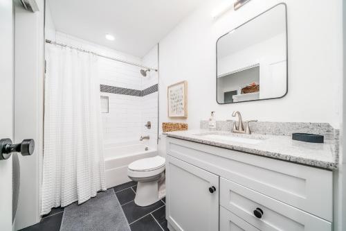 a white bathroom with a sink and a toilet at The Beehive in Lake Hamilton