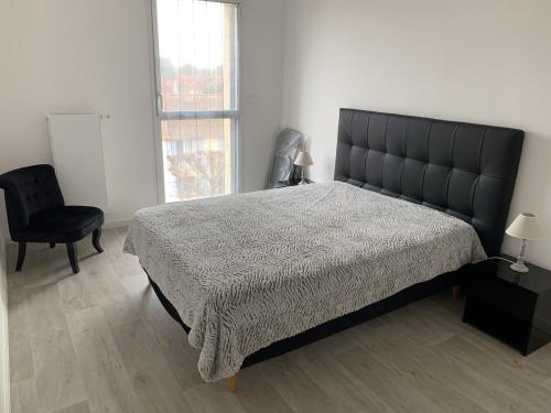 a bedroom with a bed and a chair and a window at Charmant T2 en centre-ville avec balcon, parking privé et équipements bébé à Fort-Mahon-Plage - FR-1-482-99 in Fort-Mahon-Plage
