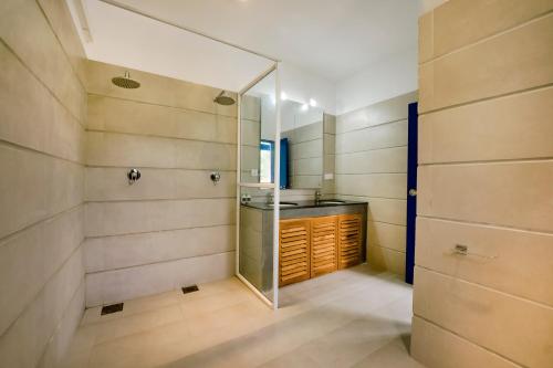 Łazienka z prysznicem i szklanymi drzwiami w obiekcie Urchin Unawatuna w mieście Unawatuna