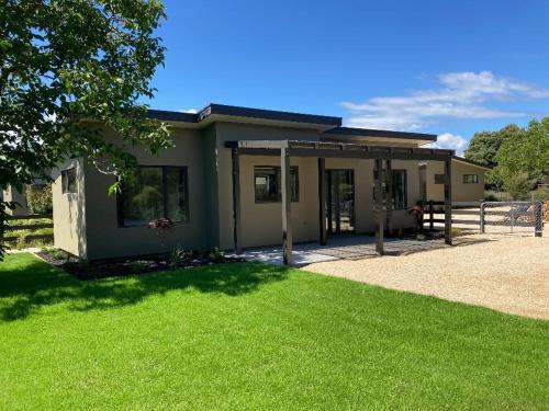 a small house with a green lawn in front of it at Country Retreats On Ranzau 0 in Hope