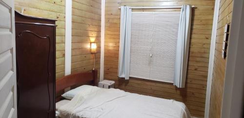 a small bedroom with a bed and a window at Casa Condomínio Boiçucanga in Boicucanga