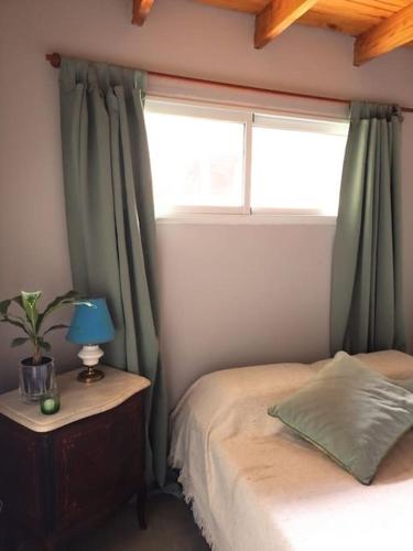 Habitación pequeña con cama y ventana en Casa en barrio cerrado, ideal para descansar en Chascomús