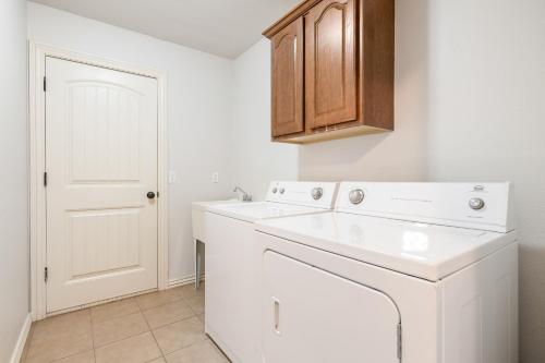 a white laundry room with a washer and dryer at Chill on the Hill in Fayetteville