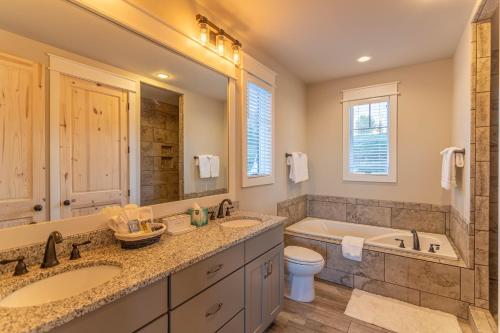 a bathroom with two sinks and a tub and a toilet at The Grape Escape at Eagles Nest in Elk Park