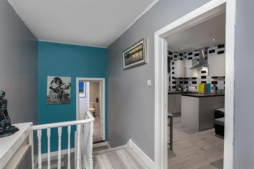 a staircase in a house with blue walls at Central Roof Terrace Apartment in Stockton-on-Tees