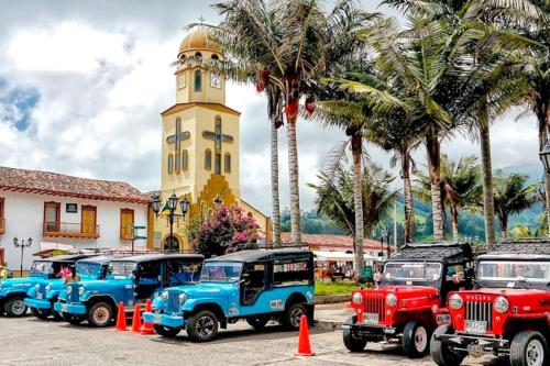 un grupo de camiones estacionados frente a una torre del reloj en vivienda turistica sara & angel 2, en Salento